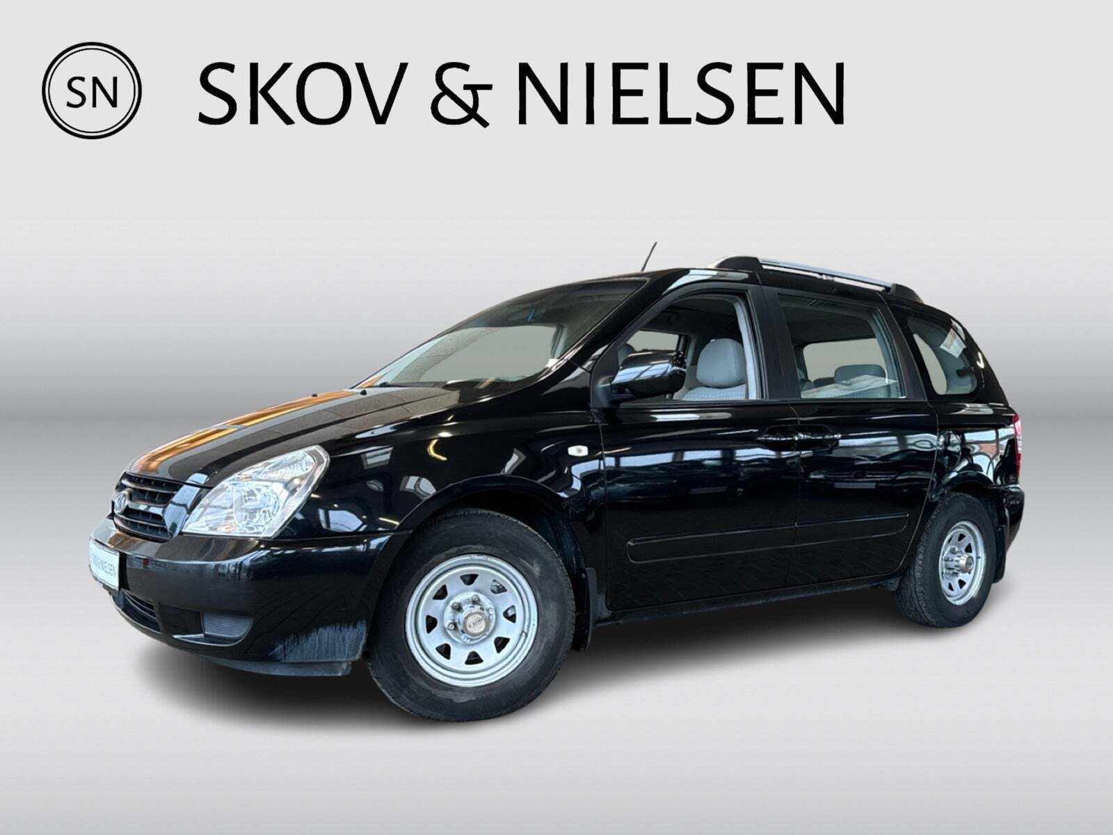 Sort Kia Carnival fra 2007 set udefra