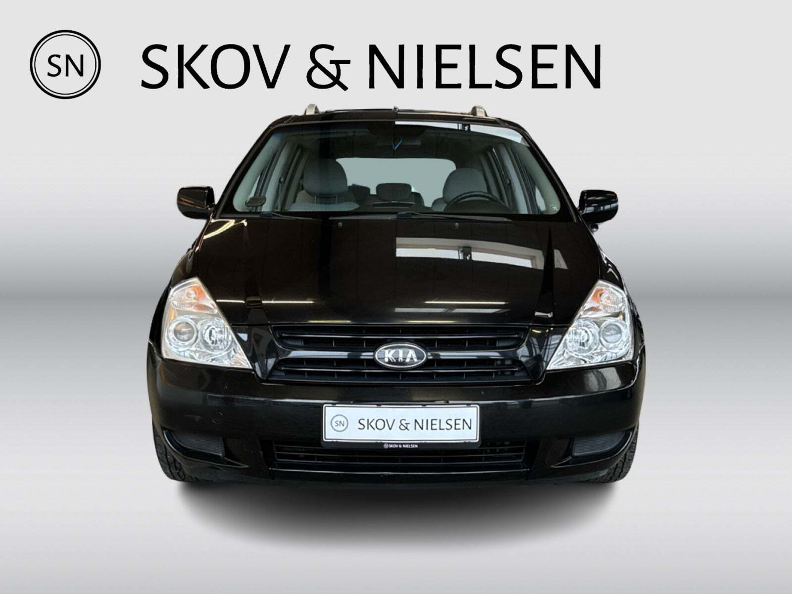 Sort Kia Carnival fra 2007 set udefra