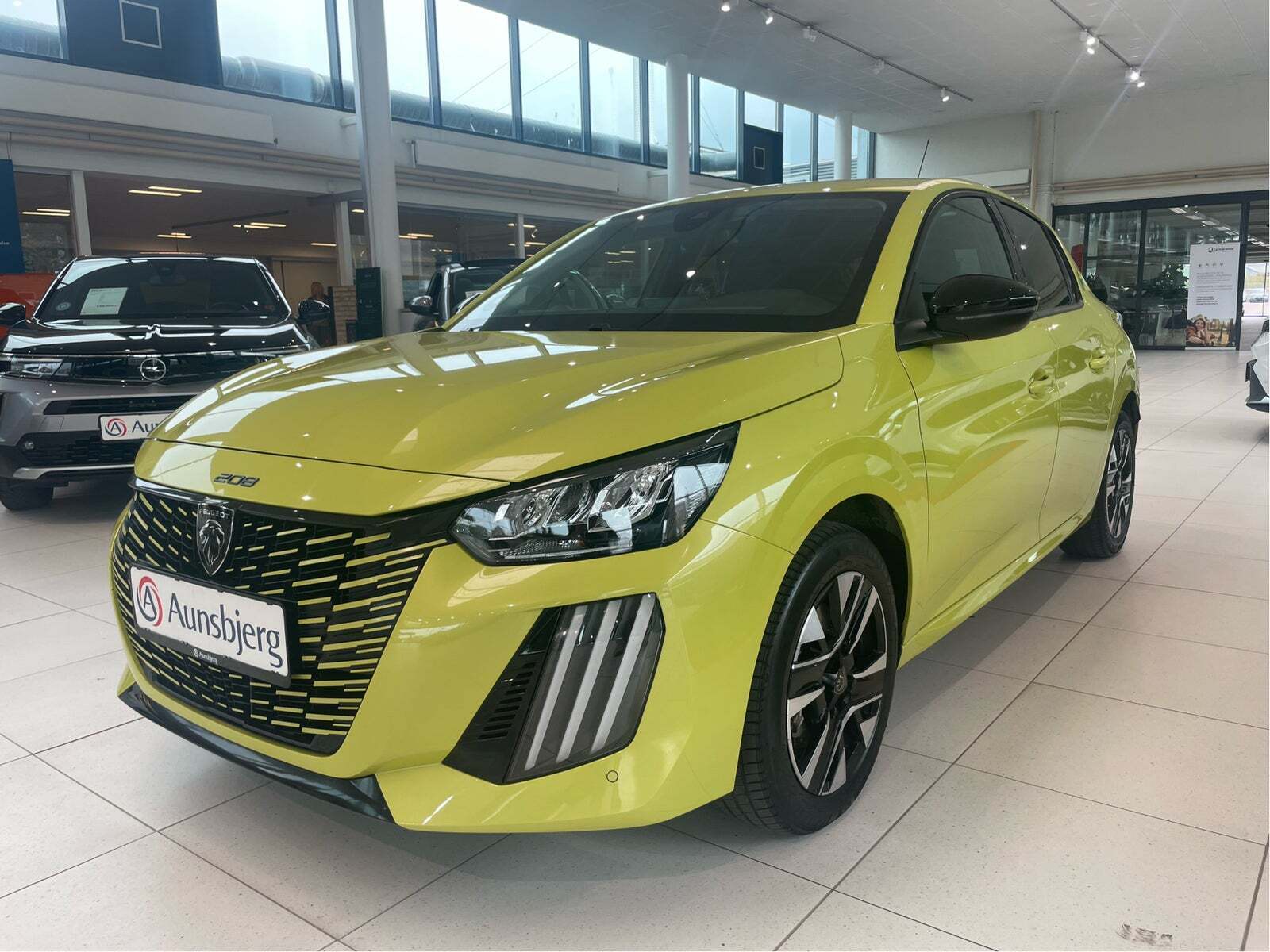 Gul Peugeot e-208 fra 2023 set udefra