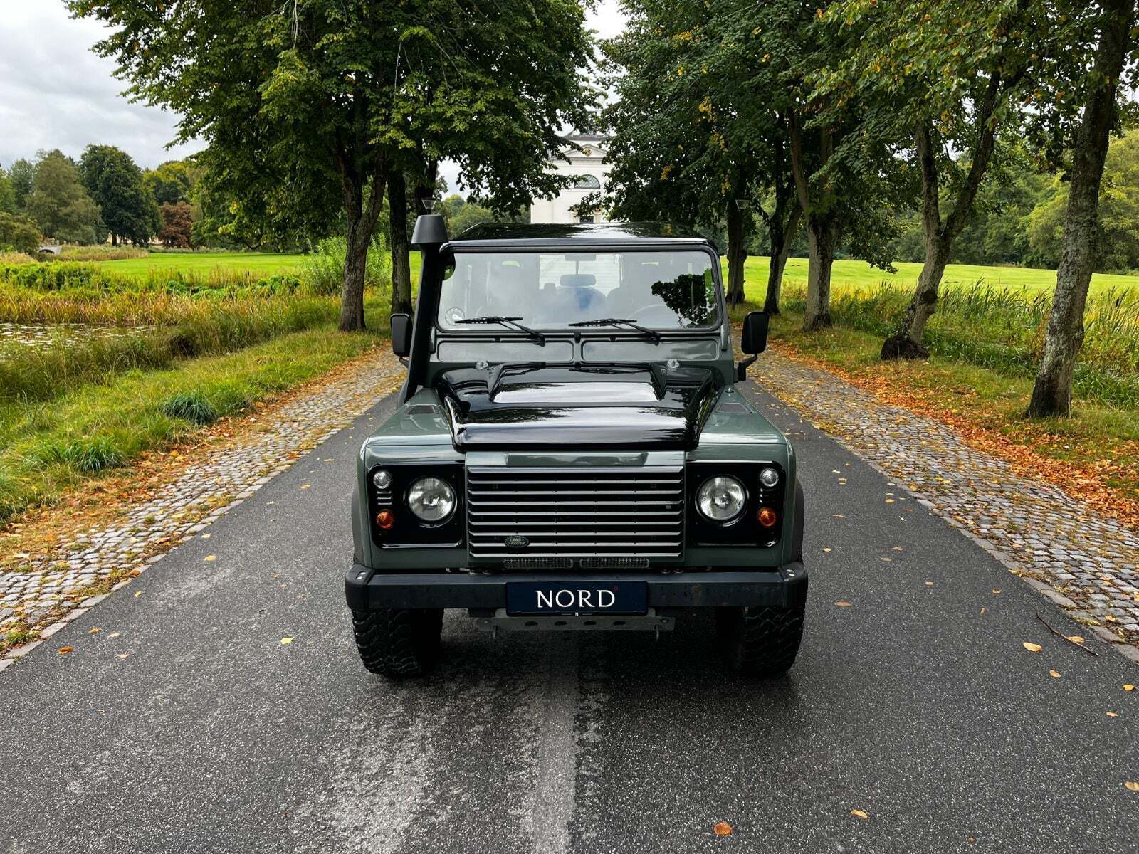 Grøn Land Rover Defender 110 fra 2013 set udefra