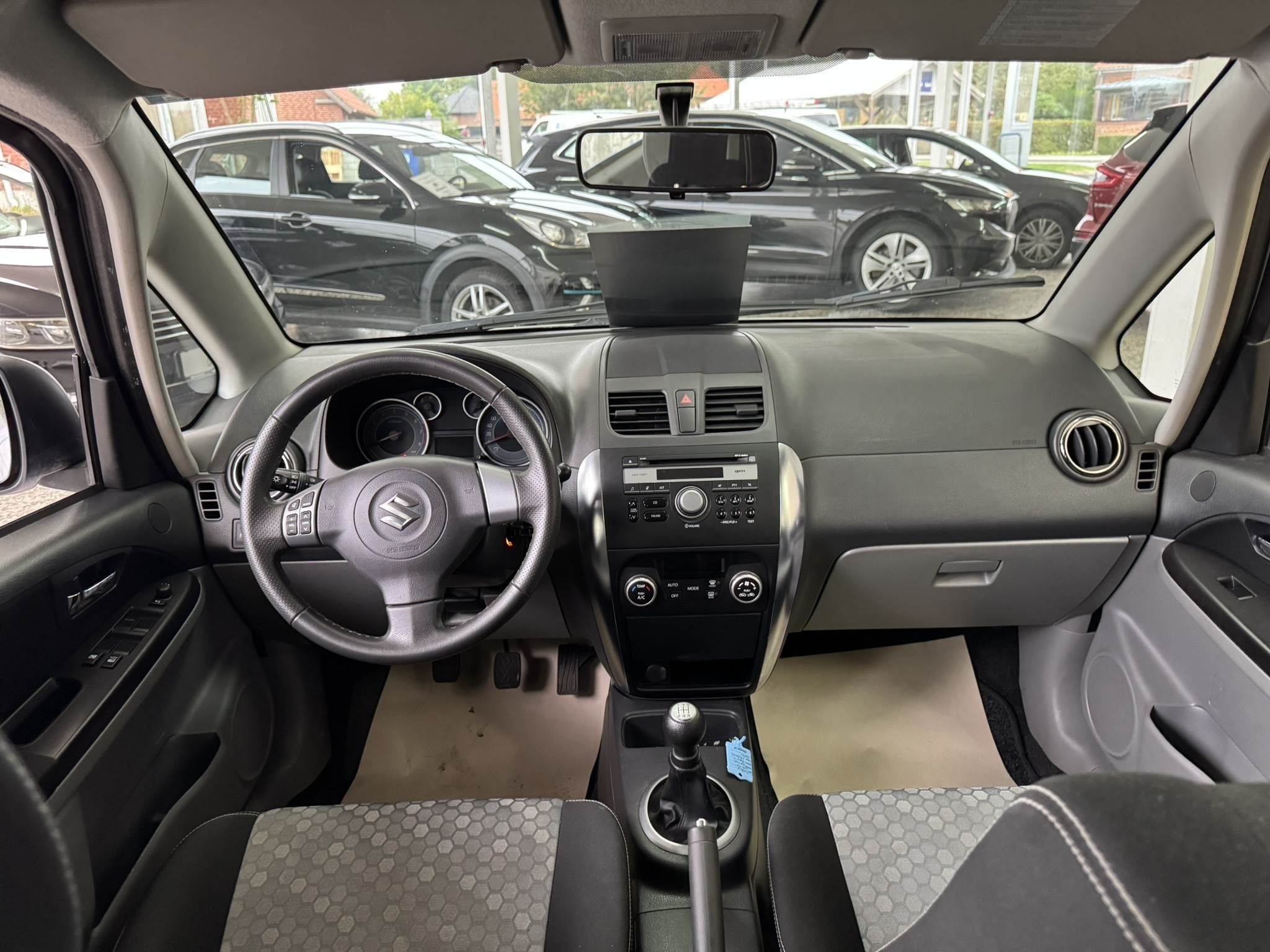 Grå Suzuki SX4 fra 2014 set indefra