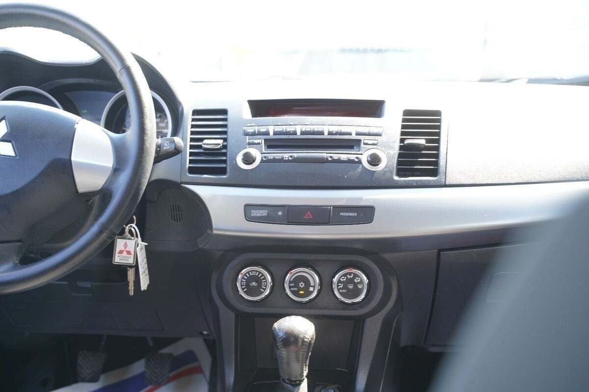 Sølv Mitsubishi Lancer fra 2011 set indefra