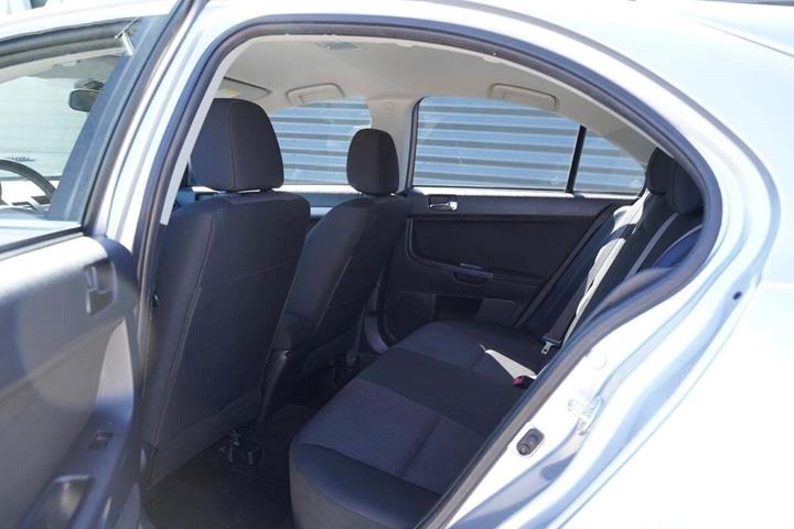 Sølv Mitsubishi Lancer fra 2011 set indefra