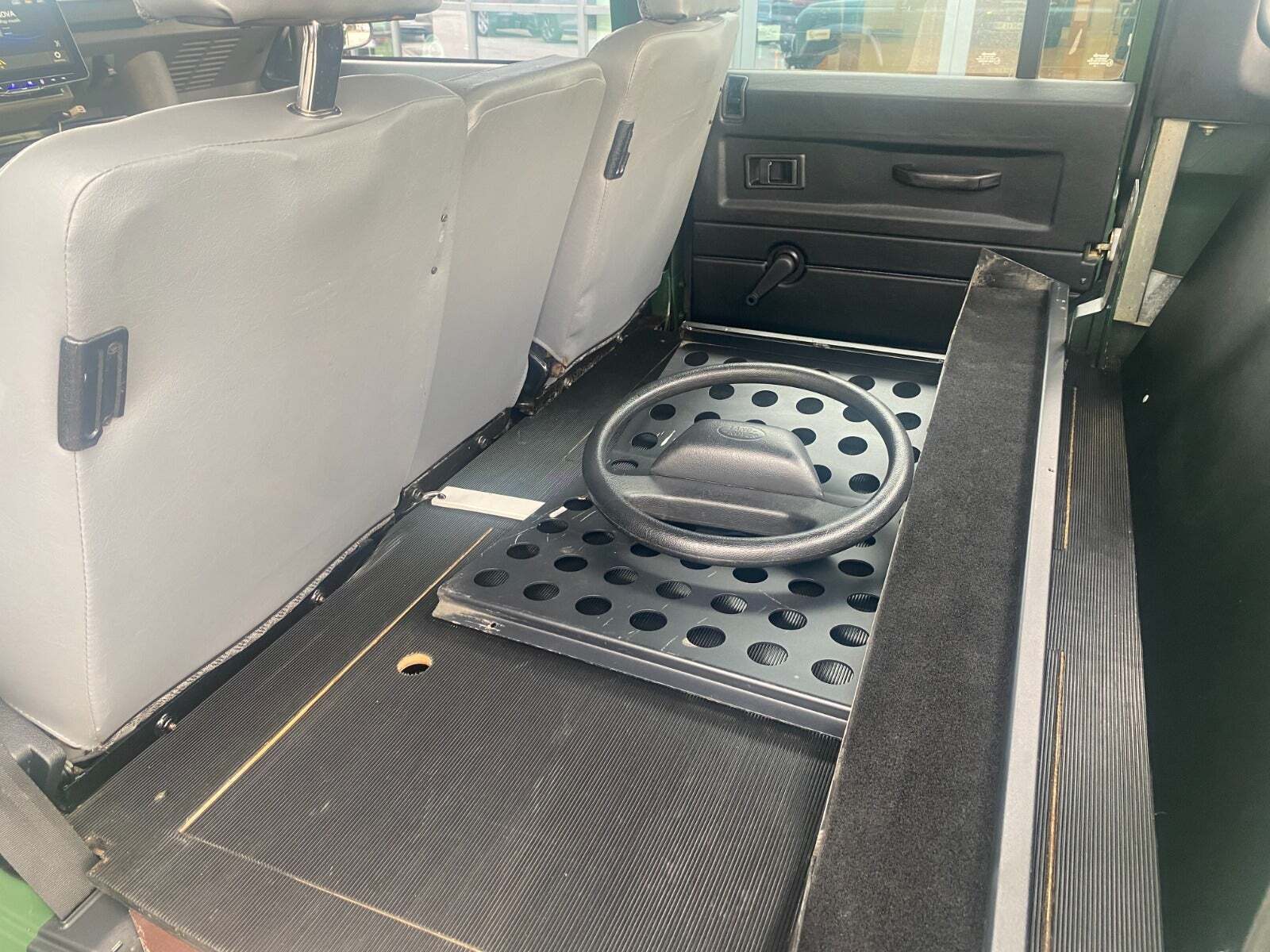 Grøn Land Rover Defender 130 fra 1999 set indefra