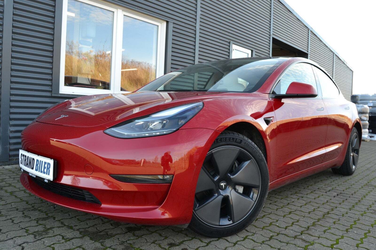 Rød Tesla Model 3 fra 2023