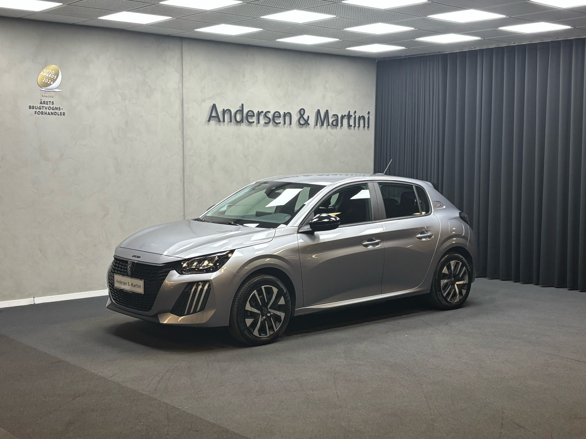 Grå Peugeot e-208 fra 2025 set udefra