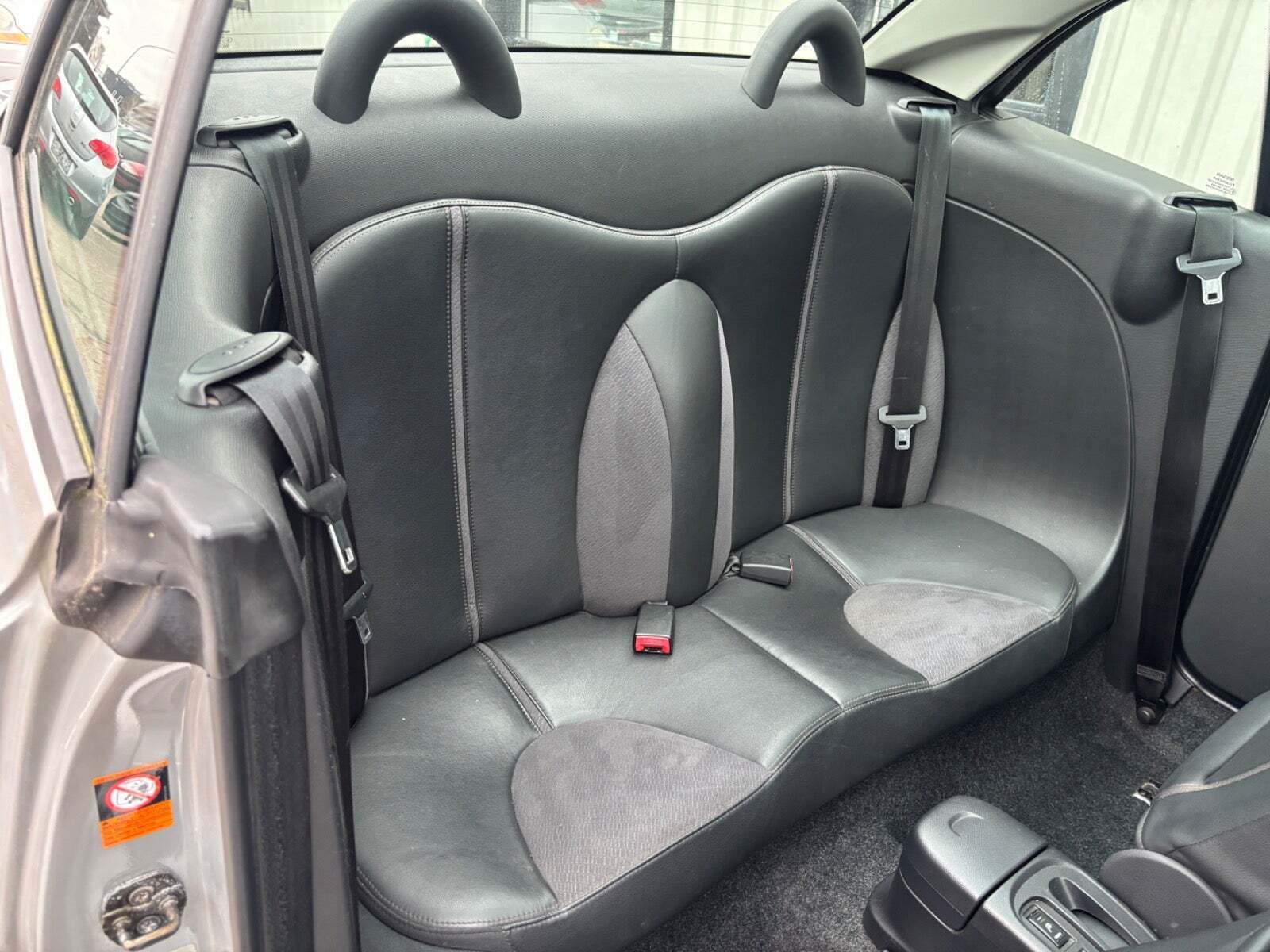 Sølv Nissan Micra C+C fra 2006 set indefra