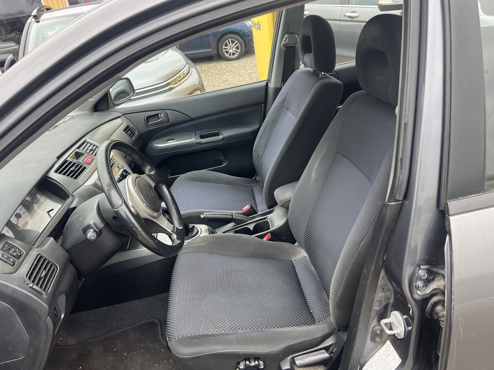 Grå Mitsubishi Lancer fra 2007 set indefra