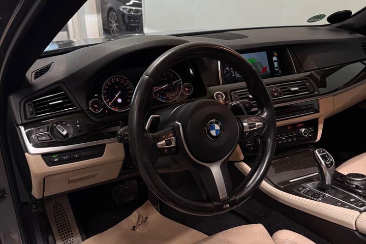 Brun BMW 550i fra 2014 set indefra