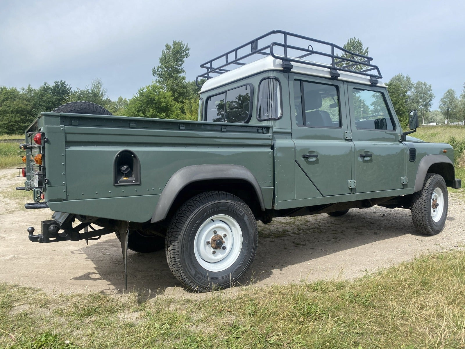 Grøn Land Rover Defender 130 fra 2013 set udefra
