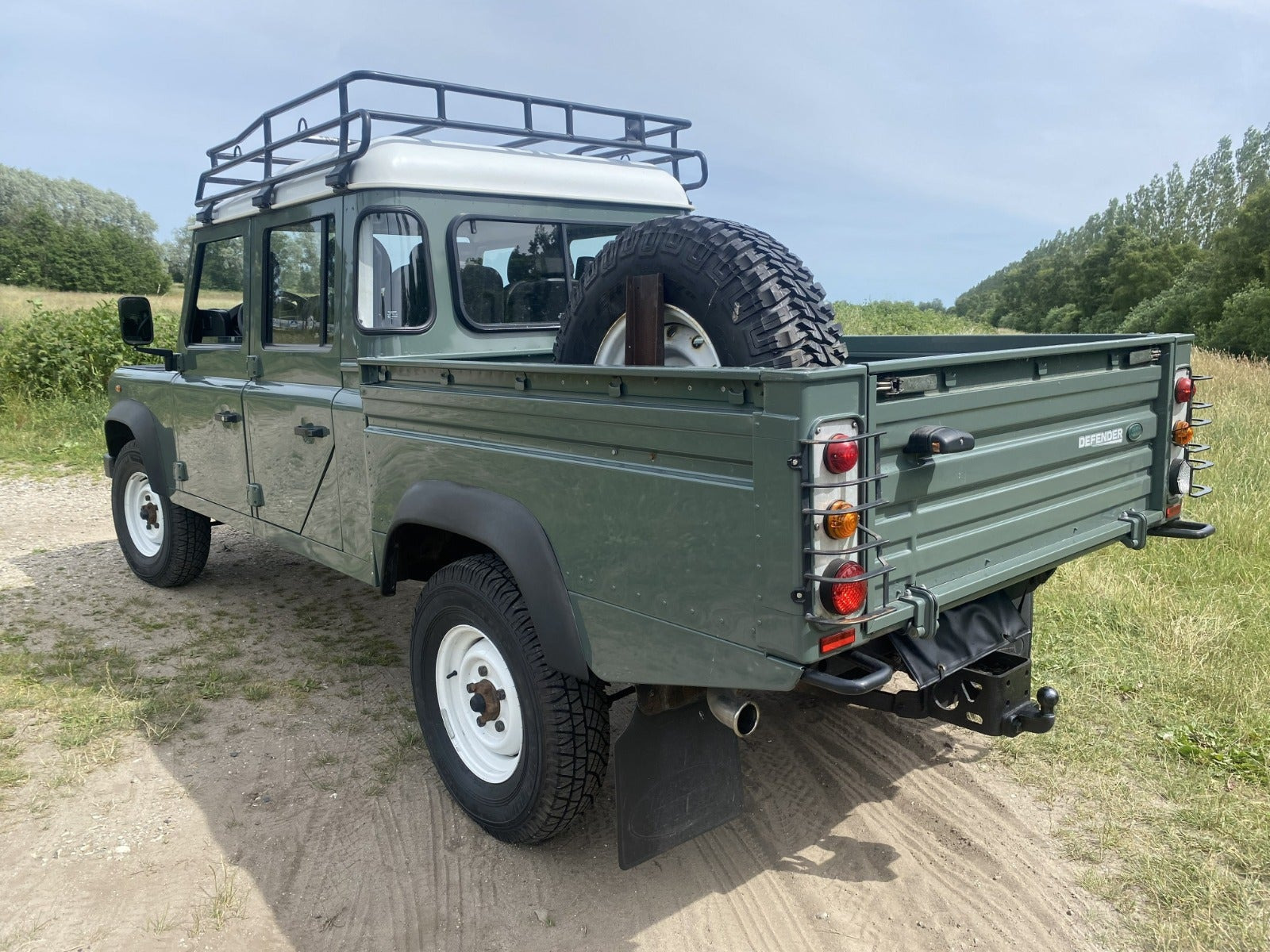 Grøn Land Rover Defender 130 fra 2013 set udefra