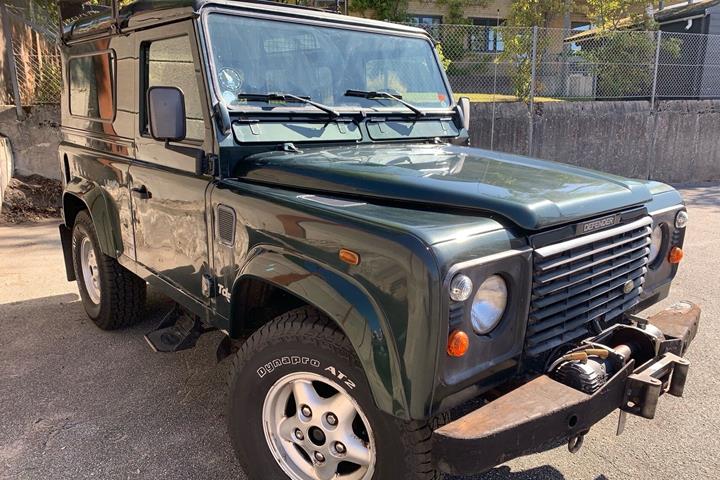 Grøn Land Rover Defender fra 1999
