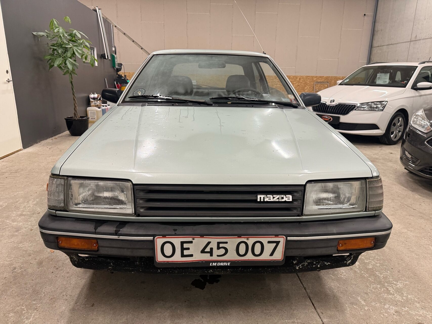Blå Mazda 323 fra 1987