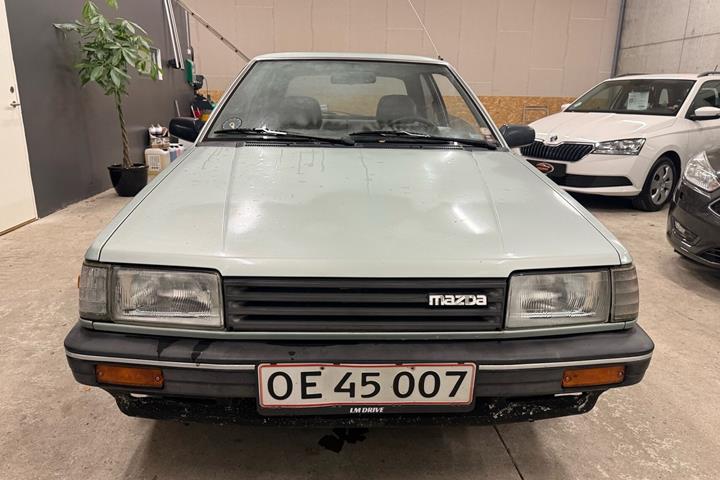 Blå Mazda 323 fra 1987
