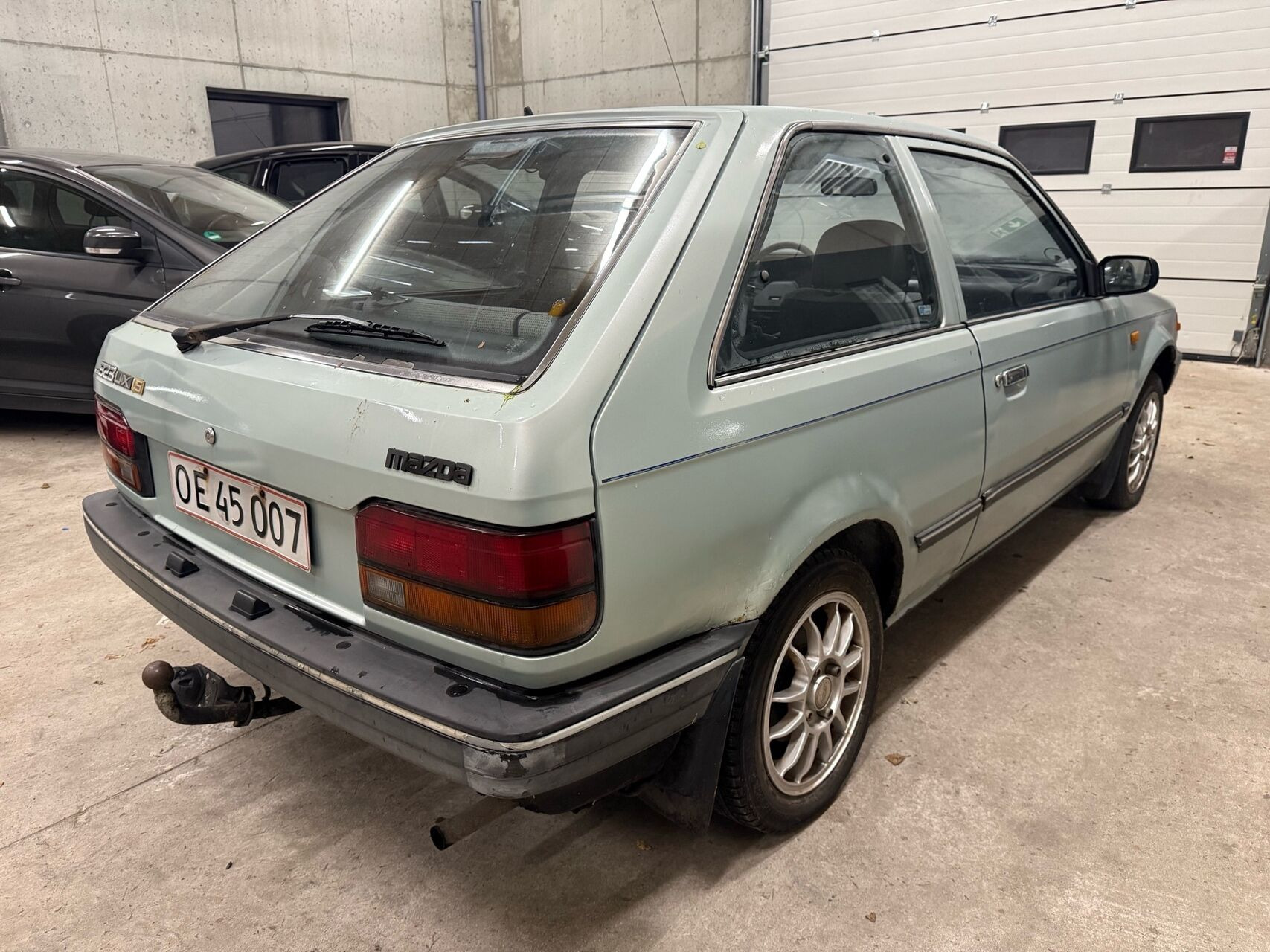 Blå Mazda 323 fra 1987