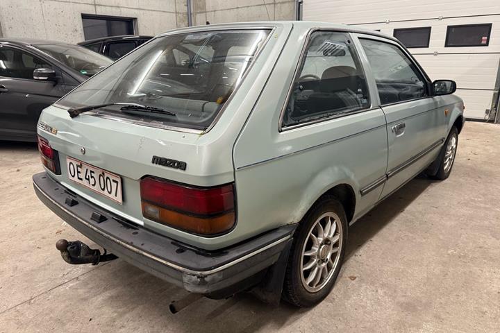 Blå Mazda 323 fra 1987