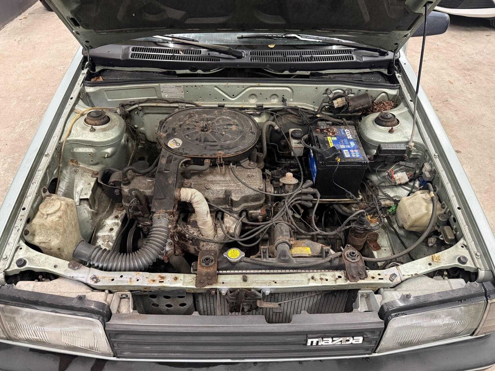 Blå Mazda 323 fra 1987